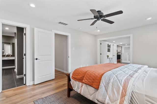 bedroom with ensuite bathroom, hardwood / wood-style floors, and ceiling fan