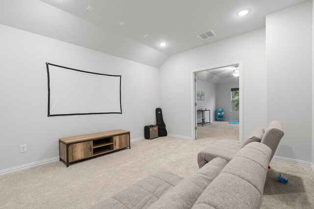 home theater featuring light colored carpet and vaulted ceiling