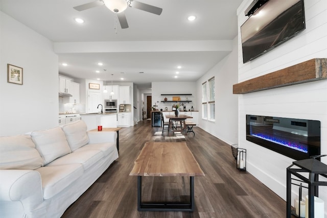 living area with baseboards, recessed lighting, a fireplace, dark wood-style floors, and a ceiling fan