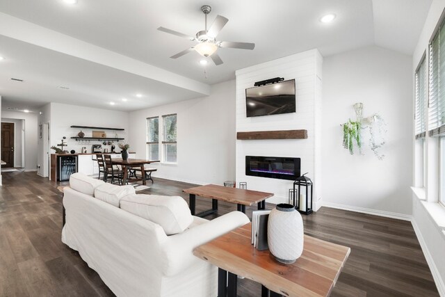 living room featuring a large fireplace, dark wood-type flooring, lofted ceiling, beverage cooler, and ceiling fan