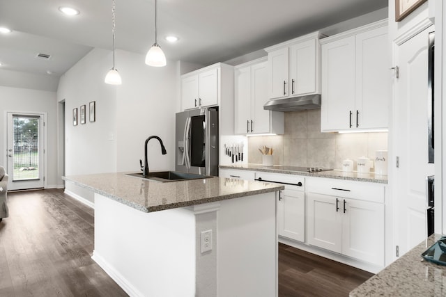 kitchen with decorative light fixtures, a center island with sink, white cabinets, and light stone countertops