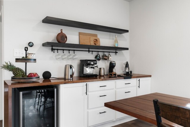 bar with beverage cooler, white cabinetry, and dark hardwood / wood-style floors