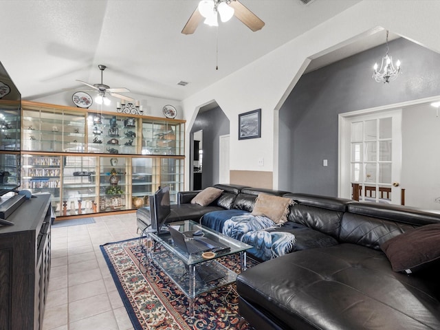 living room featuring ceiling fan with notable chandelier, light tile patterned floors, and lofted ceiling