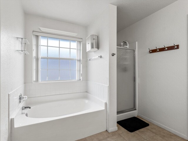 bathroom with tile patterned flooring and separate shower and tub