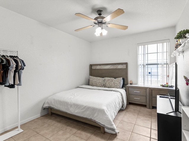 bedroom with ceiling fan and light tile patterned floors