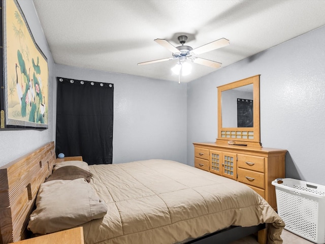 bedroom featuring ceiling fan and a textured ceiling