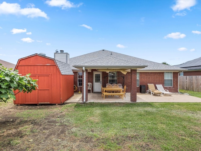 rear view of house featuring a patio area, a yard, and a shed