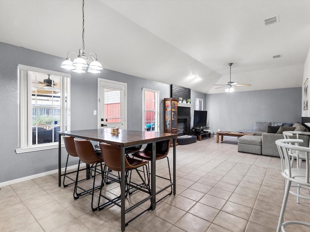 dining room featuring ceiling fan with notable chandelier, light tile patterned flooring, and lofted ceiling