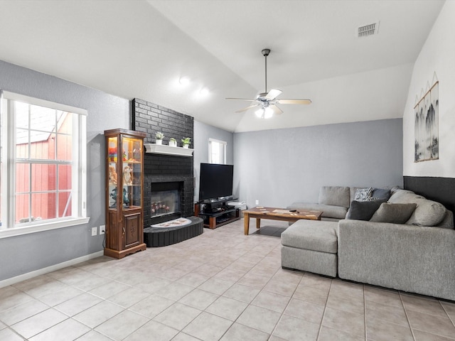 tiled living room featuring ceiling fan, lofted ceiling, and a brick fireplace