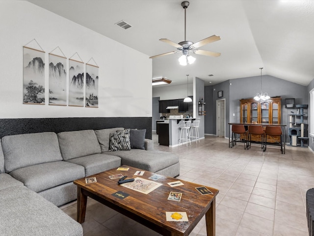 living room with vaulted ceiling, tile patterned flooring, and ceiling fan with notable chandelier