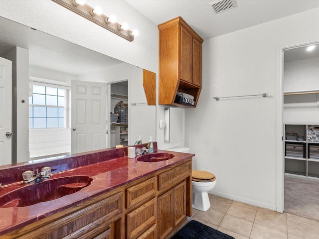 bathroom with tile patterned flooring, vanity, toilet, and a bath