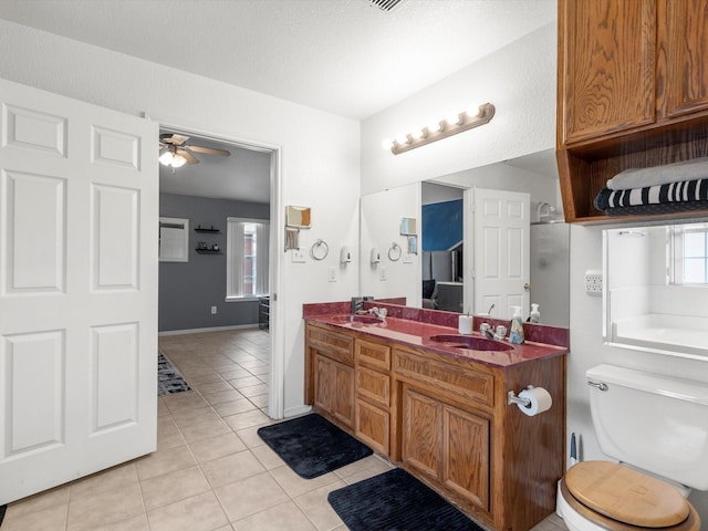 bathroom with a bathtub, vanity, tile patterned floors, ceiling fan, and toilet