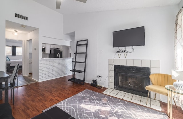 living room featuring a fireplace, ceiling fan, hardwood / wood-style floors, and lofted ceiling