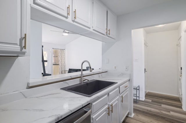 806 W 24th St Unit 300, Austin, TX 78705 - kitchen featuring a sink, white cabinets, wood finished floors, light stone counters, and dishwasher
