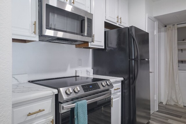 806 W 24th St Unit 300, Austin, TX 78705 - kitchen featuring stainless steel appliances, white cabinets, and light wood-style flooring