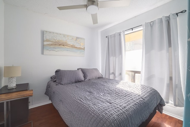 bedroom with a textured ceiling, dark hardwood / wood-style floors, and ceiling fan