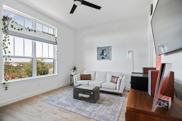 living room featuring ceiling fan, plenty of natural light, and light wood-type flooring