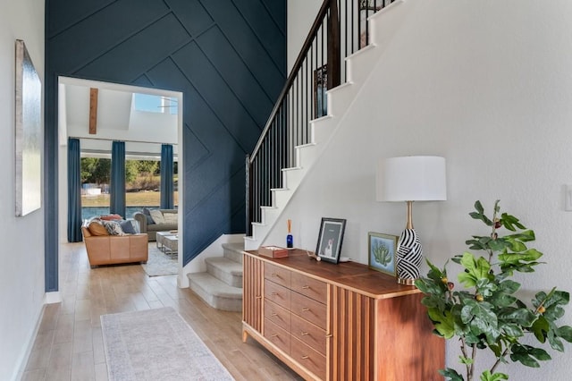 interior space with a towering ceiling and light hardwood / wood-style flooring