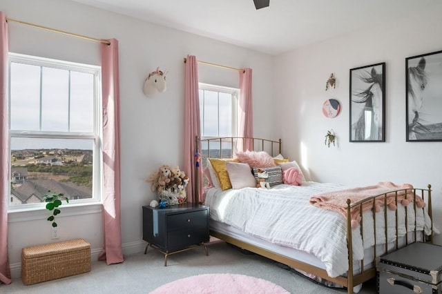 bedroom with multiple windows, ceiling fan, and light colored carpet