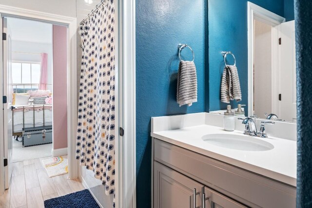 bathroom featuring a shower with shower curtain, hardwood / wood-style floors, and vanity