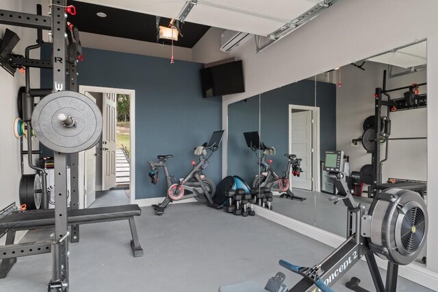 exercise room with an AC wall unit and lofted ceiling