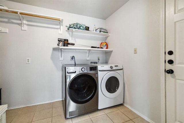 laundry room with independent washer and dryer and light tile patterned floors