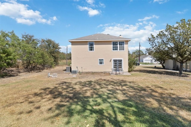 back of property with french doors, a patio, central air condition unit, and a lawn