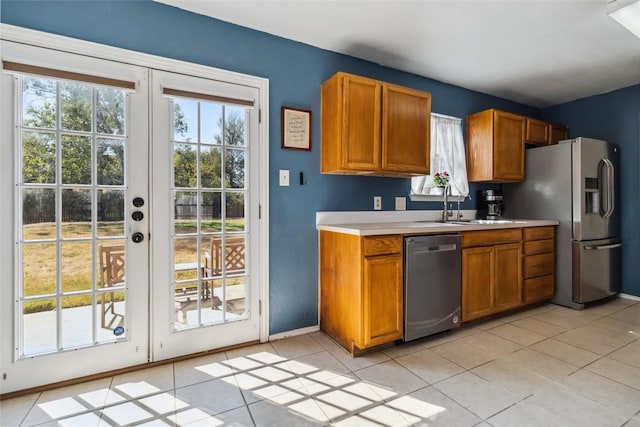 kitchen with light tile patterned floors, sink, appliances with stainless steel finishes, and french doors