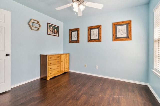 unfurnished bedroom with ceiling fan and dark wood-type flooring