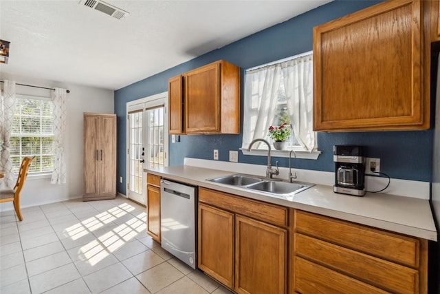 kitchen with light tile patterned flooring, french doors, stainless steel dishwasher, and sink