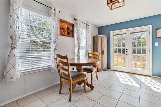 dining space with plenty of natural light, light tile patterned floors, and french doors