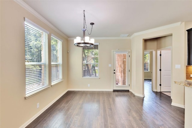 unfurnished dining area with dark hardwood / wood-style floors, crown molding, and a notable chandelier