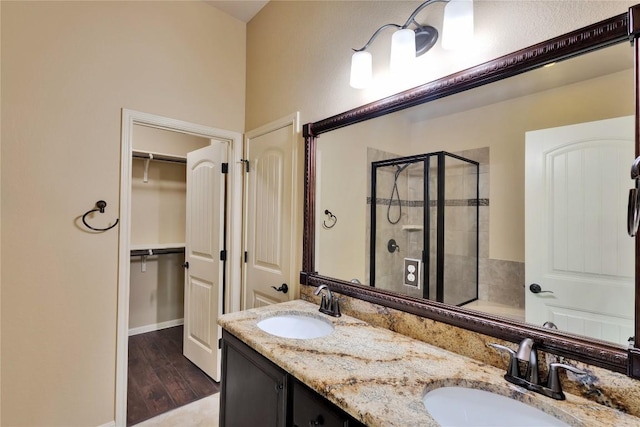 bathroom with hardwood / wood-style floors, vanity, and a shower with shower door