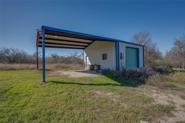 exterior space with a carport, a garage, an outbuilding, and a lawn