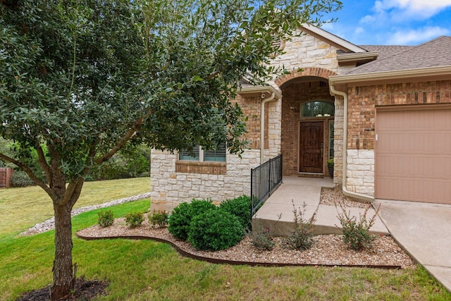 doorway to property with a yard and a garage