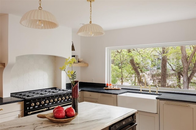 kitchen with pendant lighting, high end stove, and sink