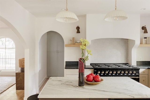 kitchen featuring high end black range oven, a kitchen island, and plenty of natural light