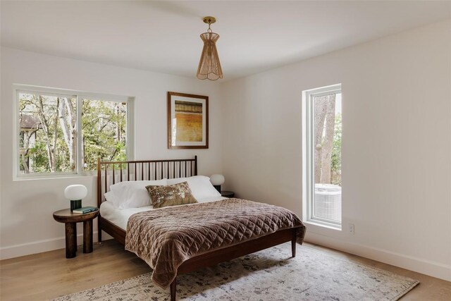 bedroom with light hardwood / wood-style flooring and multiple windows