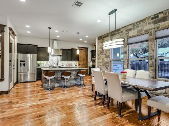 dining space with light wood-type flooring and sink