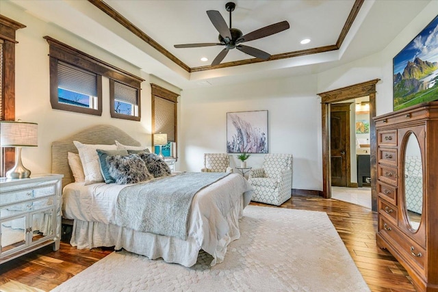 bedroom with recessed lighting, a tray ceiling, wood finished floors, and ornamental molding