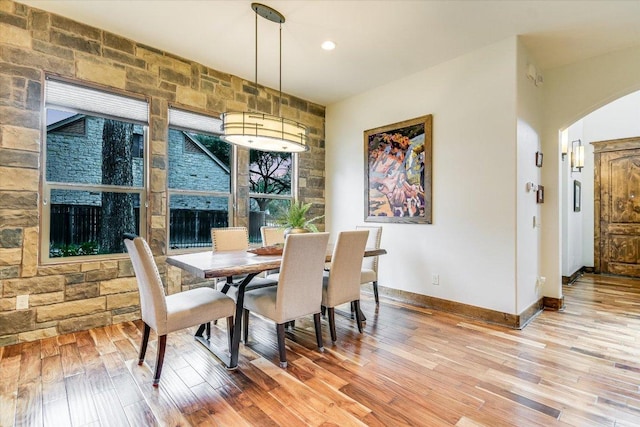 5608 Clay Ave Unit A, Austin, TX 78756 - dining room featuring arched walkways, light wood finished floors, and baseboards