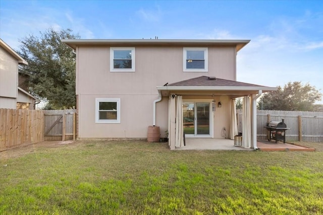 rear view of property featuring a yard and a patio