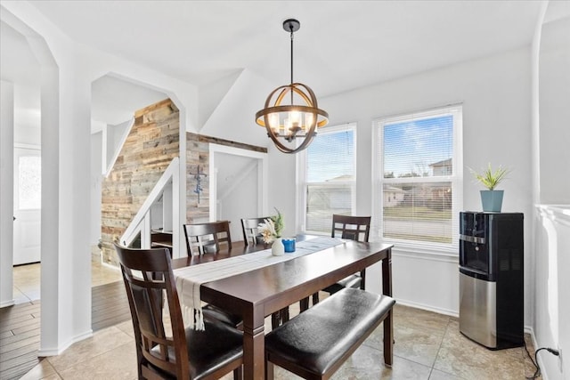 tiled dining room featuring a notable chandelier