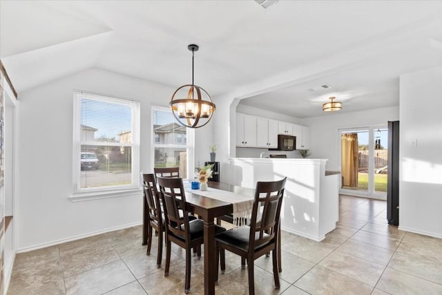 tiled dining room with a notable chandelier and lofted ceiling