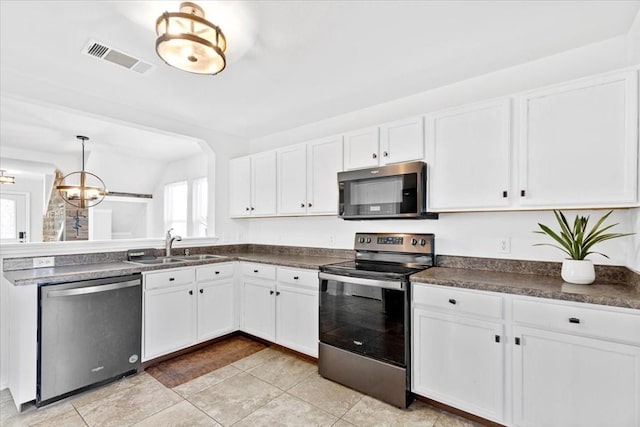 kitchen featuring a chandelier, white cabinets, pendant lighting, and appliances with stainless steel finishes