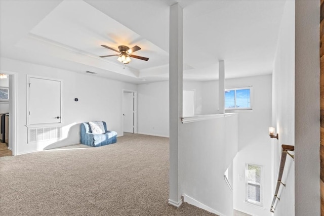 interior space with carpet floors and a raised ceiling