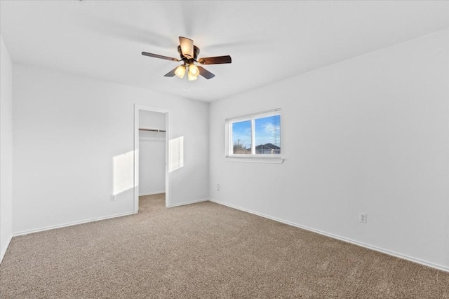 unfurnished bedroom with ceiling fan, a closet, carpet floors, and a spacious closet