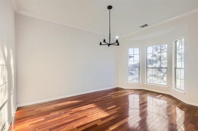 unfurnished dining area with a wealth of natural light, crown molding, hardwood / wood-style flooring, and a notable chandelier