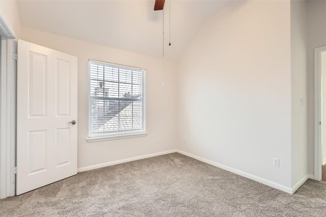 spare room featuring vaulted ceiling, ceiling fan, and light colored carpet