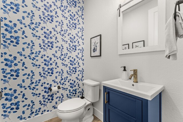 bathroom with vanity, toilet, and baseboards